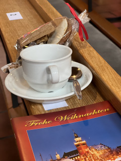 Kaffeetasse mit abgepackten Plätzchen und Liederheft